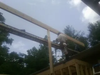 Carpenter setting a ridge beam over a new addition frame — Ice Dam Removal by Roofing Brothers in Oostburg