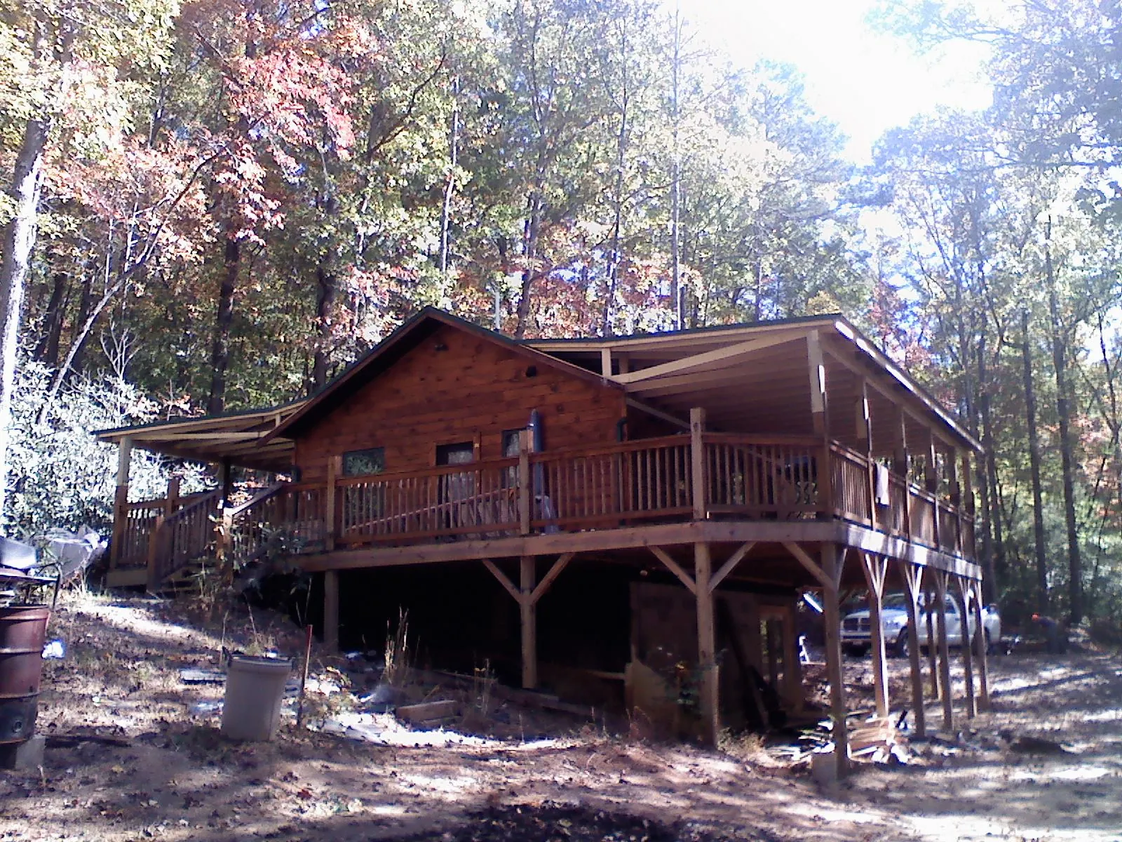 Log cabin with a wraparound porch and metal roof in the fall in Oostburg