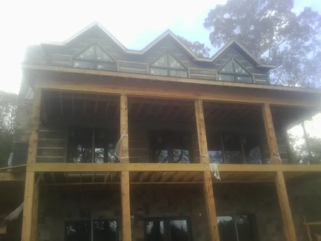 Dormers and porch framing on a large log home under construction — Roof Coating work by our crew in Oostburg
