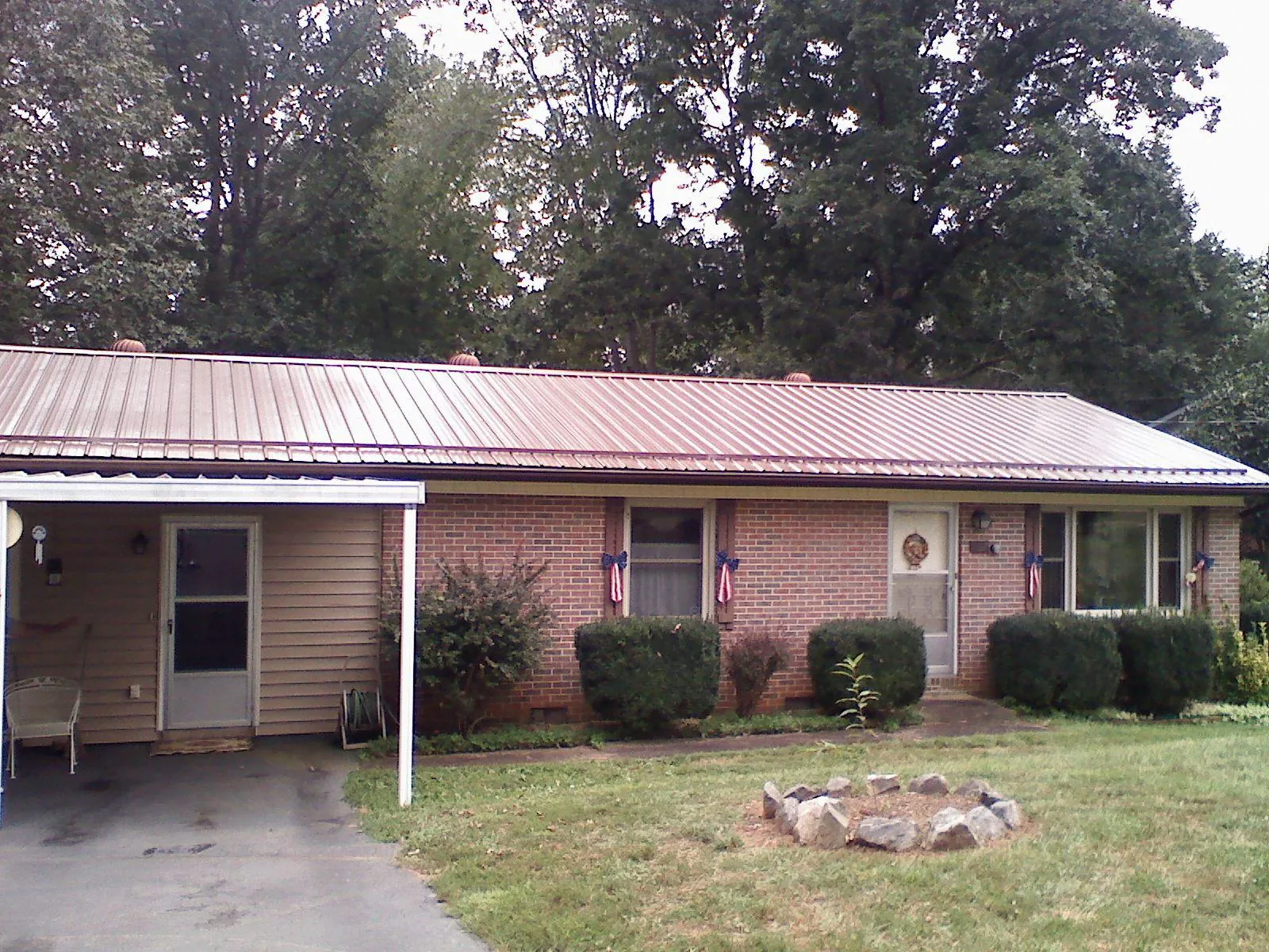 Bronze metal roof and carport on a brick ranch home — Roof Repair work by our crew in Oostburg